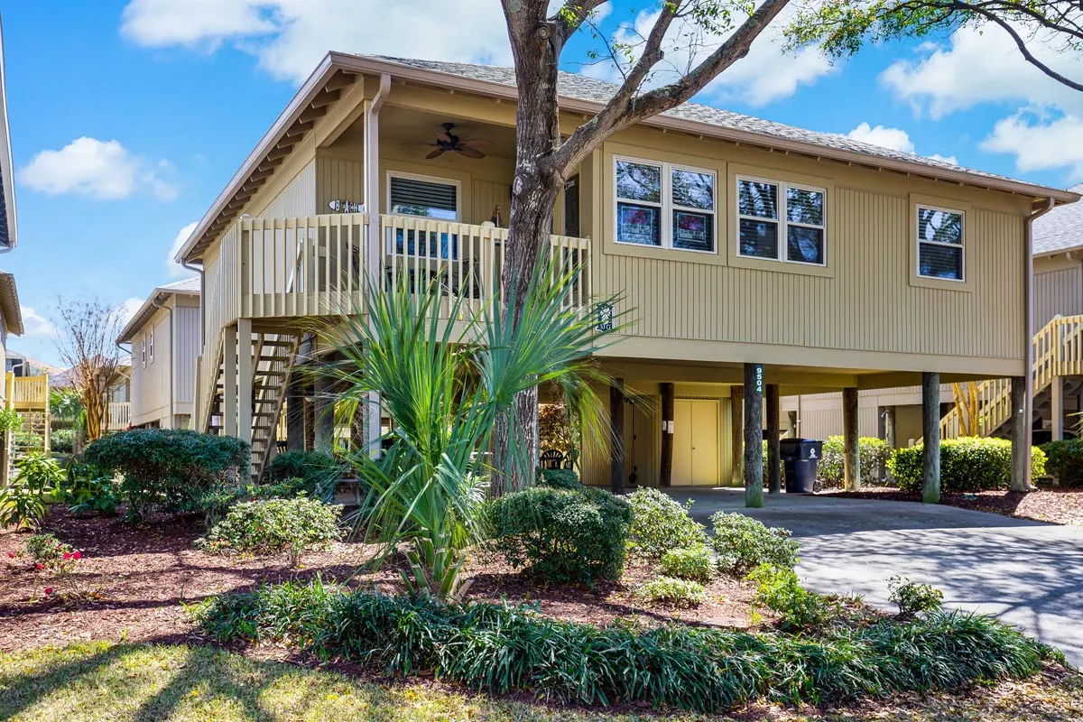 A raised beach house with a covered porch and parking underneath at Guest Cottages